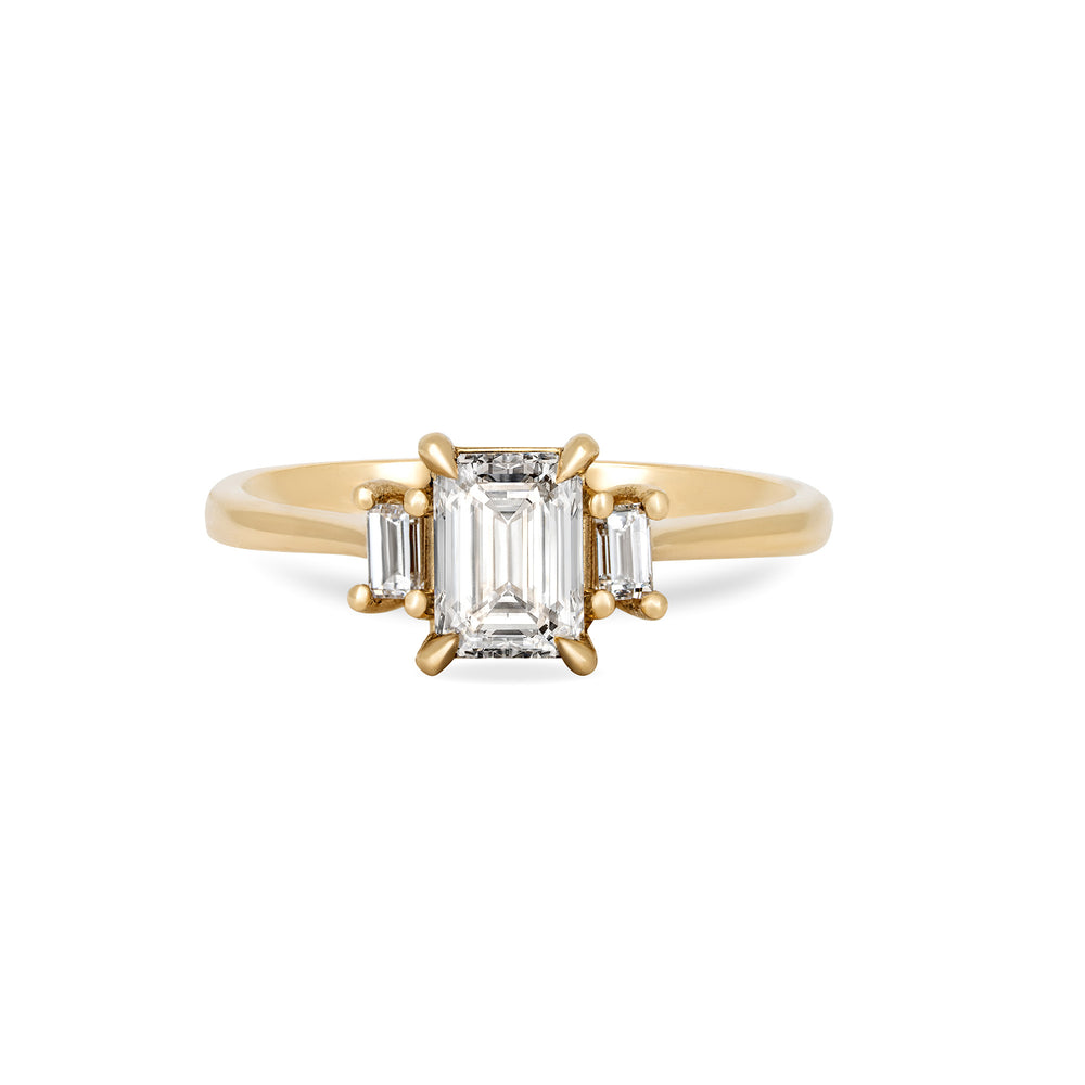 Front view of the Hero Emerald Cut Three Stone Diamond Engagement Ring in 14k solid gold, featuring a central 1ct emerald-cut diamond flanked by two smaller diamonds on a polished band.