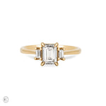 Front view of the Hero Emerald Cut Three Stone Diamond Engagement Ring in 14k solid gold, featuring a central 1ct emerald-cut diamond flanked by two smaller diamonds on a polished band.