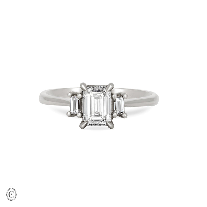 Front view of the Hero Emerald Cut Three Stone Diamond Engagement Ring in 14k solid white gold, featuring a central 1ct emerald-cut diamond flanked by two smaller diamonds on a polished band.