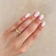 Close-up of a hand wearing the Driftwood 4mm Wedding Band in 14k white gold.
