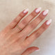 Close-up of a hand wearing the Follow Your Heart Diamond Wedding Ring in 14k white gold on a twig band.