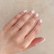 Close-up of a hand wearing the Hawthorn Twig Ring in 14k white gold.