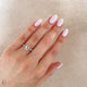 Close-up of a hand wearing the Heritage Eternity Emerald Cut Diamond Engagement Ring in 14k white gold.