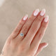Close-up of a hand wearing the Hero Emerald Cut Three Stone Diamond Engagement Ring in 14k solid gold.