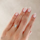 Close-up of a hand wearing the Moonlight Oval Diamond Engagement Ring in 14k white gold, on a polished band.
