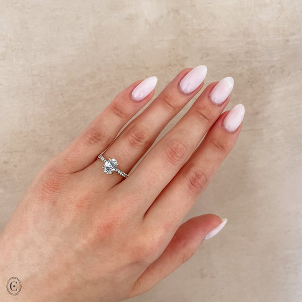 Alternative view of Close-up of a hand wearing the Moonlight Eternity Oval Diamond Engagement Ring in 14k white gold.