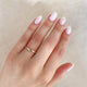 Close-up of a hand wearing the Timeless Love 2mm Wedding Band in 14k gold.