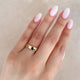 Close-up of a hand wearing the Timeless Love 5mm Polished Wedding Band in 14k solid gold.