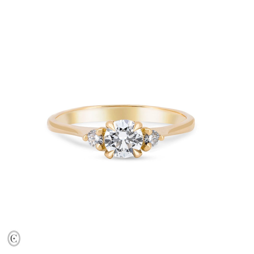 Front view of the You, Me & Magic Round Cut Three Stone Engagement Ring in 14k solid gold, featuring a 0.5ct central round cut diamond flanked by two smaller stones on a polished band.